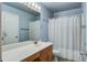 Bathroom with wood cabinets, a large mirror, and a shower curtain, well illuminated by overhead lighting at 113 Ashton Cv, Summerville, SC 29485