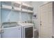 A well-equipped laundry room with a washer, dryer, storage shelves, and a convenient side door at 113 Ashton Cv, Summerville, SC 29485
