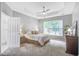 This primary bedroom features a tray ceiling, ceiling fan, and large window with a view of the surrounding greenery at 113 Ashton Cv, Summerville, SC 29485