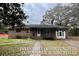 Exterior shot of a single story brick home with a covered front porch and mature trees at 113 Germantown Rd, Summerville, SC 29483