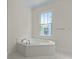 Bright bathroom with a tiled corner tub and window offering natural light and neighborhood view at 1150 Quick Rabbit Loop, Charleston, SC 29414
