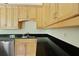Bright kitchen featuring wood cabinets, black countertops, and stainless steel dishwasher at 1150 Quick Rabbit Loop, Charleston, SC 29414