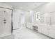 Well-lit bathroom with walk-in shower, double vanity, marble flooring, and view to Primary bedroom at 117 Osprey Ridge Ln, Summerville, SC 29483