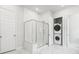 Modern bathroom featuring frameless glass shower, marble tile flooring, and stacked laundry at 117 Osprey Ridge Ln, Summerville, SC 29483