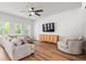 Bright living room featuring hardwood floors, two sofas, an armchair, and a media cabinet at 117 Osprey Ridge Ln, Summerville, SC 29483