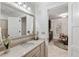 Bathroom featuring a vanity with neutral marble top, a decorative mirror, and a glimpse into the dining area at 121 W Shipyard Rd, Mount Pleasant, SC 29464