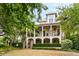 Charming two-story home with a landscaped front yard and a double porch with white pillars at 121 W Shipyard Rd, Mount Pleasant, SC 29464
