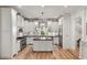 Bright, modern kitchen with white cabinetry, stainless steel appliances, wooden floors and a center island at 121 W Shipyard Rd, Mount Pleasant, SC 29464