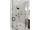Glass enclosed shower stall featuring neutral stone tile and a modern shower head and faucet at 121 W Shipyard Rd, Mount Pleasant, SC 29464