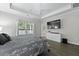 A Primary bedroom featuring a tray ceiling, a ceiling fan, large windows, and a modern dresser at 1221 Lois Allen Rd, Johns Island, SC 29455