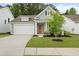 Charming single-Gathering home featuring a two-car garage, gray siding, orange door with wreath, and landscaped front yard at 1221 Lois Allen Rd, Johns Island, SC 29455