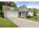 Charming single-Gathering home featuring a two-car garage, gray siding, orange door, and well-maintained landscaping at 1221 Lois Allen Rd, Johns Island, SC 29455