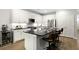 A modern kitchen with white cabinets, stainless steel appliances, and a black countertop with barstool seating at 1221 Lois Allen Rd, Johns Island, SC 29455