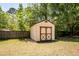 Backyard storage shed featuring wooden doors and siding on a grass lawn surrounded by a wood fence at 133 Tall Spruce Rd, Moncks Corner, SC 29461