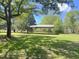 Backyard area features grass, metal carport, and mature trees providing ample shade at 1425 Risher Mountain Rd, Walterboro, SC 29488