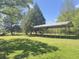 Backyard area features grass, metal carport, and mature trees providing ample shade at 1425 Risher Mountain Rd, Walterboro, SC 29488