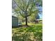 Spacious backyard with green lawn, trees, exterior of the house, and carport at 1425 Risher Mountain Rd, Walterboro, SC 29488