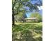 Backyard area features grass, metal carport, and mature trees providing ample shade at 1425 Risher Mountain Rd, Walterboro, SC 29488