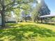 Spacious backyard with green lawn, carport, and the exterior of the house screened-in back porch at 1425 Risher Mountain Rd, Walterboro, SC 29488