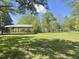 Backyard area features grass, metal carport, and mature trees providing ample shade at 1425 Risher Mountain Rd, Walterboro, SC 29488