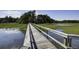 Wooden boardwalk extends over a marshy landscape, connecting to a wooded area under a partly cloudy sky at 148 Cowrie Ct, Mount Pleasant, SC 29464