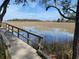 Idyllic marsh scene with a wooden boardwalk bordered by lush vegetation and a serene body of water at 148 Cowrie Ct, Mount Pleasant, SC 29464