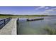 A wooden dock extends into a calm waterway, offering serene views and access to the water at 148 Cowrie Ct, Mount Pleasant, SC 29464