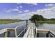 A wooden dock extends into a calm waterway, offering serene views and access to the water at 148 Cowrie Ct, Mount Pleasant, SC 29464