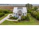 Beautiful two-story home showcasing lush landscaping, a metal roof, and a view of a marshy river at 1500 Bower Ln, Johns Island, SC 29455