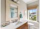 This bathroom has neutral walls, tile floors, and a large window with a view of the neighborhood at 1500 Bower Ln, Johns Island, SC 29455