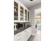 Butler's pantry with glass-front cabinets, granite countertops, and convenient laundry access at 1500 Bower Ln, Johns Island, SC 29455