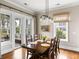 Elegant dining room with a large table, stylish lighting, and access to an outdoor balcony at 1500 Bower Ln, Johns Island, SC 29455
