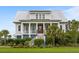 Charming two-story home featuring a metal roof, elevated porch, and manicured landscaping at 1500 Bower Ln, Johns Island, SC 29455