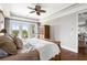 This main bedroom has hardwood floors, white walls, a ceiling fan, and access to a deck overlooking the water at 1500 Bower Ln, Johns Island, SC 29455