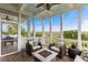 Cozy screened-in porch featuring a fire pit, comfortable seating, and stunning marshland views at 1500 Bower Ln, Johns Island, SC 29455