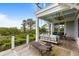 Relaxing covered porch with swing, lounge chair, ceiling fan, and a view of marshy waterways at 1500 Bower Ln, Johns Island, SC 29455