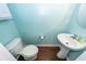 Compact powder room features wood flooring, blue walls, pedestal sink, and modern toilet at 151 Kirkland St, Goose Creek, SC 29445
