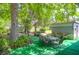 View of a dining table with chairs on artificial turf surrounded by lush trees at 1575 Langston Dr, Johns Island, SC 29455