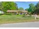 Charming single story home with bright yellow door and well-maintained front yard with flowerbeds at 1575 Langston Dr, Johns Island, SC 29455