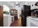 A kitchen with white cabinets and a black refrigerator, featuring wood flooring and a ceiling fan at 1575 Langston Dr, Johns Island, SC 29455