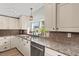 Detailed view of granite countertops, and stainless dishwasher in a kitchen with pendant lights at 1616 Refuge Run, Charleston, SC 29412