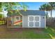 Charming backyard shed with a covered porch, surfboard and ample storage space, great for hobbies at 1616 Refuge Run, Charleston, SC 29412