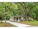 Inviting white brick home with a long driveway and lush landscaping, creating a welcoming curb appeal at 1621 Point Park Dr, Johns Island, SC 29455