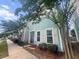 Charming two-story home featuring a quaint porch, black metal fencing, and an inviting, well-maintained yard at 1661 Indy Dr, North Charleston, SC 29405