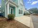 Light blue home displaying the porch and sidewalk, with manicured bushes surrounding the front of the home at 1661 Indy Dr, North Charleston, SC 29405