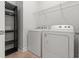 Laundry area equipped with a white washer, dryer, wire rack shelving, and a dark shelving unit at 1661 Indy Dr, North Charleston, SC 29405