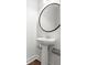 Simple powder room features a pedestal sink, round mirror, and elegant fixtures at 1661 Indy Dr, North Charleston, SC 29405