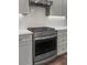 Close-up of a stainless steel gas range with light colored cabinets and white backsplash at 1661 Indy Dr, North Charleston, SC 29405
