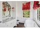 Elegant bathroom with marble countertops, ornate mirror, soaking tub and bright window at 172 Tradd St, Charleston, SC 29401