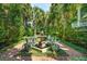 Inviting brick courtyard with a stone fountain feature, complemented by lush palm trees and manicured greenery at 172 Tradd St, Charleston, SC 29401